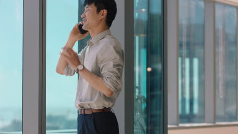 asian-businessman-using-smartphone-chatting-to-client-financial-advisor-negotiating-business-deal-corporate-sales-executive-sharing-expert-advice-having-phone-call-in-office-looking-out-window