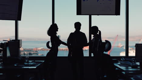 silhouette-business-people-shaking-hands-consultant-greeting-international-clients-with-handshake-planning-partnership-deal-female-executive-meeting-shareholders-in-corporate-office-at-sunset