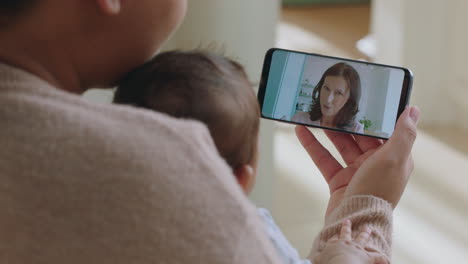 Joven-Madre-Y-Bebé-Teniendo-Video-Chat-Con-Abuela-Usando-Un-Teléfono-Inteligente-Saludando-A-Su-Nieto-Disfrutando-De-Una-Conexión-Familiar-Charlando-Por-Teléfono-Móvil