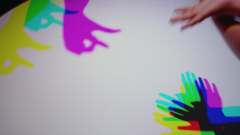 Bunte-Hände-Machen-Schattenpuppen.-Kinder-Haben-Spaß-Beim-Spielen-In-Mehrfarbigem-Licht.-Kinder-Genießen-Ein-Spielerisches-Spiel-Mit-Regenbogenfarbenen-Silhouetten