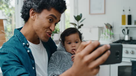 Video-Chat-Zwischen-Vater-Und-Kind-über-Das-Smartphone.-Glücklicher-Vater-Hält-Kleinkind-In-Der-Hand,-Teilt-Den-Vaterschaftslebensstil-Mit-Einem-Freund-In-Den-Sozialen-Medien-Und-Genießt-Mobile-Technologie-In-4K