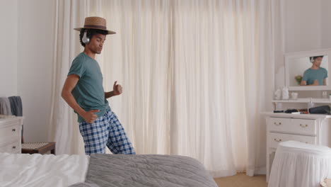 happy-young-man-dancing-in-bedroom-celebrating-success-listening-to-music-wearing-headphones-having-fun-dance-in-on-weekend-morning-wearing-pajamas