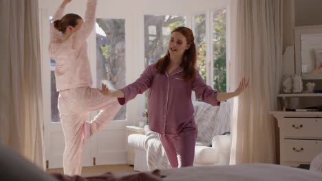 Adolescentes-Felices-Practicando-Movimientos-De-Baile-De-Ballet-En-El-Dormitorio,-Mejores-Amigos-Divirtiéndose-Ensayando-El-Fin-De-Semana-Por-La-Mañana-Usando-Pijamas