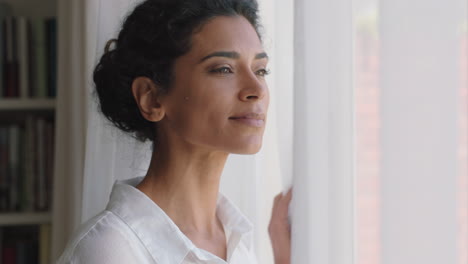 beautiful-mixed-race-woman-looking-out-window-at-home-enjoying-fresh-new-day-feeling-rested-thinking-planning-ahead-4k-footage
