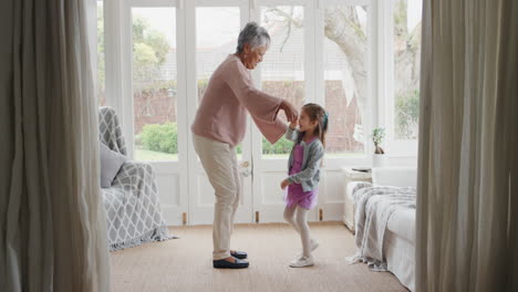 cute-little-girl-dancing-with-grandmother-funny-granny-having-fun-dance-with-granddaughter-celebrating-family-weekend-at-home-4k