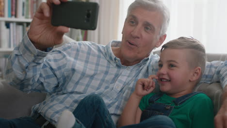 Großvater-Und-Kind-Unterhalten-Sich-Per-Video-Per-Smartphone.-Kleiner-Junge-Teilt-Sein-Urlaubswochenende-Mit-Der-Familie.-Opa-Genießt-Es,-Zu-Hause-Mit-Seinem-Enkel-über-Mobile-Technologie-Zu-Chatten