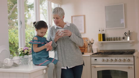 cute-little-girl-showing-grandmother-how-to-use-smartphone-teaching-granny-modern-technology-intelligent-child-helping-grandma-with-mobile-phone-at-home
