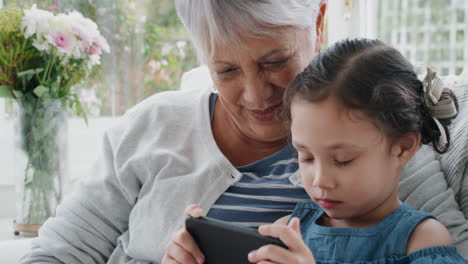 little-girl-using-smartphone-with-grandmother-having-video-chat-waving-at-family-sharing-vacation-weekend-with-granny-chatting-on-mobile-phone-relaxing-at-home-with-granddaughter-4k