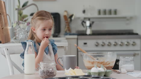 cute-little-girl-eating-chocolate-in-kitchen-having-fun-baking-cupcakes-4k