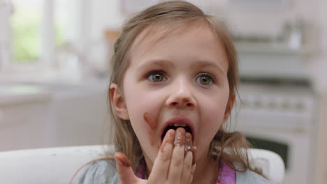 cute-little-girl-with-hands-covered-in-chocolate-licking-fingers-having-fun-baking-in-kitchen-naughty-child-enjoying-tasty-treat-at-home
