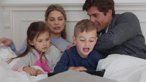 Glückliche-Familie,-Die-Vor-Dem-Schlafengehen-Einen-Tablet-Computer-Nutzt,-Mutter-Und-Vater-Mit-Kindern,-Die-Sich-Unterhaltung-Ansehen,-Ein-Spiel-Auf-Einem-Touchscreen-Gerät-Spielen-Und-Lernen,-Gemeinsam-Zu-Hause-Spaß-Zu-Haben,-4K-Videos