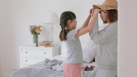 asian-mother-and-daughter-playing-dress-up-game-at-home-little-girl-having-fun-with-mom-enjoying-playful-day-with-child-together-on-weekend-happy-family-4k-footage