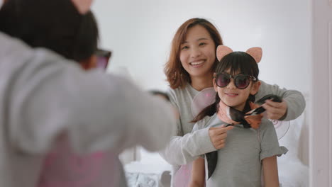 asian-mother-and-daughter-playing-dress-up-game-at-home-little-girl-having-fun-with-mom-enjoying-playful-day-with-child-together-on-weekend-happy-family-4k-footage