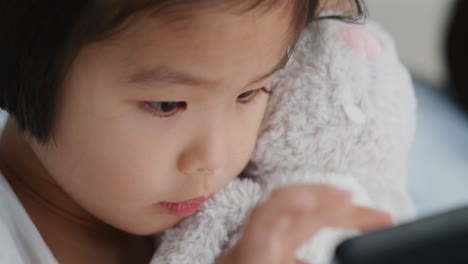 cute-little-asian-girl-using-tablet-computer-with-family-enjoying-playing-games-on-touchscreen-device-relaxing-at-home-together-4k