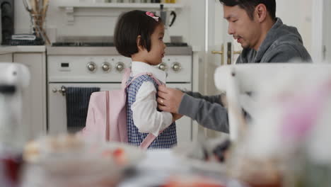 little-asian-girl-getting-ready-for-school-happy-father-preparing-daughter-for-first-day-kissing-her-on-head-saying-goodbye-4k