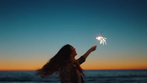 woman-dancing-with-sparklers-on-beach-at-sunset-celebrating-new-years-eve-girl-having-fun-dance-with-sparkler-fireworks-enjoying-independence-day-celebration-by-the-sea