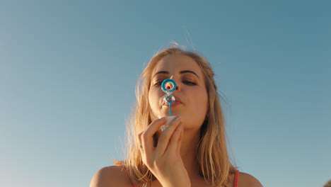 happy-young-woman-blowing-bubbles-on-beach-at-sunset-enjoying-summer-having-fun-on-vacation-by-the-sea