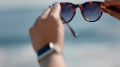 Nahaufnahme-Der-Hände-Einer-Frau-Mit-Sonnenbrille-Am-Schönen-Sommerstrand,-Die-Ihren-Urlaub-Am-Meer-Genießt