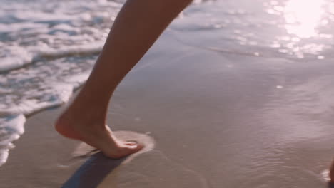 Nahaufnahme-Der-Füße-Einer-Frau,-Die-Bei-Sonnenuntergang-Barfuß-Am-Strand-Läuft-Und-Die-Sanft-Plätschernden-Wellen-Genießt.-Weibliche-Touristin-Im-Sommerurlaub