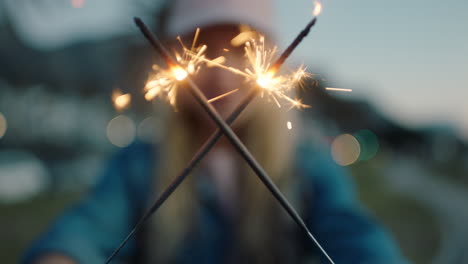 close-up-sparklers-woman-celebrating-new-years-eve-at-sunset-enjoying-independence-day-celebration-4th-of-july