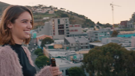 happy-multiracial-couple-laughing-having-fun-enjoying-rooftop-view-of-city-chatting-sharing-connection-friends-drinking-alcohol-hanging-out-on-weekend