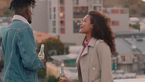 happy-multiracial-couple-chatting-having-fun-enjoying-rooftop-view-of-city-sharing-connection-friends-drinking-alcohol-hanging-out-on-weekend
