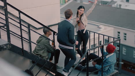 group-of-young-multiracial-friends-walking-up-fire-escape-stairs-to-rooftop-party-chatting-sharing-excitement-for-weekend-celebration