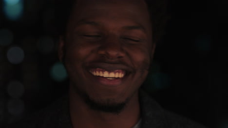 Retrato-De-Un-Apuesto-Hombre-Afroamericano-En-La-Azotea-Por-La-Noche-Bebiendo-Alcohol-Sonriendo-Feliz-Disfrutando-De-La-Vida-Nocturna-Urbana-Con-Luces-Bokeh-De-La-Ciudad-En-El-Fondo