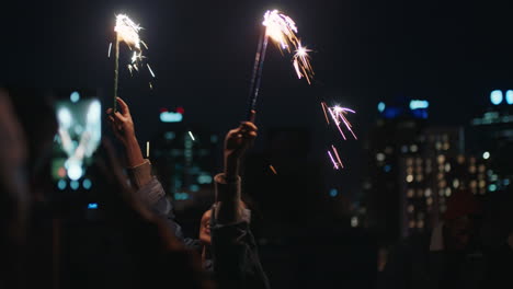 happy-young-asian-woman-holding-sparklers-dancing-on-rooftop-at-night-celebrating-new-years-eve-enjoying-holiday-party-celebration