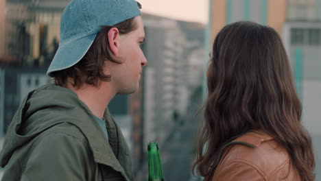 happy-caucasian-couple-chatting-enjoying-rooftop-view-of-city-sharing-connection-drinking-alcohol-hanging-out-on-weekend-date-at-sunset