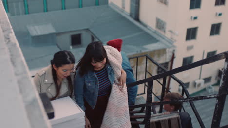 group-of-young-multiracial-friends-walking-up-fire-escape-stairs-ready-for-rooftop-party-chatting-sharing-excitement-for-weekend-celebration