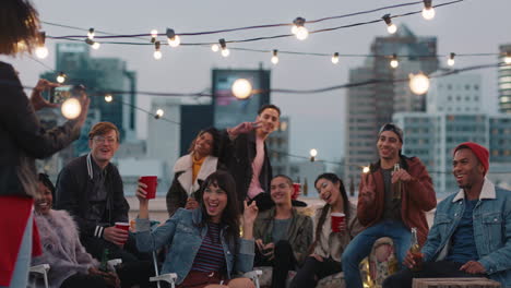 multi-ethnic-group-of-friends-posing-for-photo-on-rooftop-party-at-sunset-students-enjoying-weekend-gathering-in-urban-city