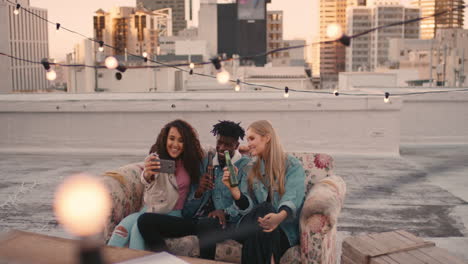 happy-multi-ethnic-friends-enjoying-rooftop-party-drinking-alcohol-taking-selfie-photos-using-smartphone-sharing-fun-weekend-on-social-media-at-sunset