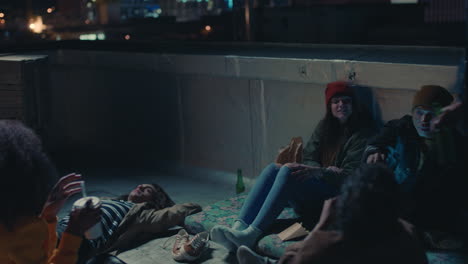 young-group-of-friends-relaxing-on-rooftop-at-night-hanging-out-having-casual-conversation-sharing-snacks-enjoying-relaxing-weekend-party-gathering