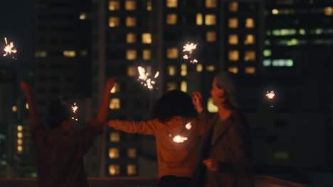 happy-friends-holding-sparklers-celebrating-new-years-eve-on-rooftop-at-sunset-having-fun-enjoying-holiday-party-celebration