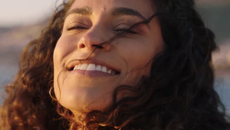 close-up-portrait-of-beautiful-happy-woman-enjoying-freedom-exploring-spirituality-feeling-joy-on-peaceful-beach-at-sunrise-with-wind-blowing-hair