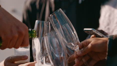 close-up-young-man-pouring-champagne-group-of-friends-celebrating-rooftop-party-drinking-alcohol-enjoying-reunion-celebration-at-sunset