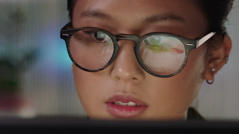 Primer-Plano-Retrato-Hermosa-Mujer-De-Negocios-Asiática-Trabajando-Hasta-Tarde-Usando-Una-Tableta-Explorando-Datos-De-Gráficos-Financieros-Mirando-Información-En-La-Pantalla-Con-Gafas