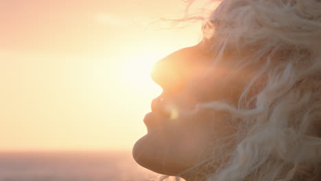 Nahaufnahme-Des-Porträts-Einer-Schönen-Blonden-Frau,-Die-Bei-Sonnenuntergang-Das-Friedliche-Meer-Genießt-Und-über-Eine-Reise-Nachdenkt,-Die-Spiritualität-Erforscht-Und-Mit-Windwehenden-Haaren-Freiheit-Empfindet