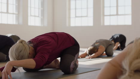 Yoga-Kurs-Von-Gesunden,-Reifen-Frauen,-Die-Die-Pose-Ihres-Kindes-Praktizieren-Und-Das-Morgendliche-Körperliche-Fitnesstraining-Im-Studio-Genießen