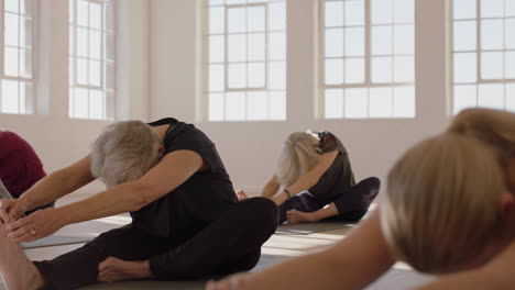 Clase-De-Yoga-De-Una-Mujer-Madura-Sana-Practicando-La-Pose-De-Flexión-Hacia-Adelante-De-La-Cabeza-A-La-Rodilla-Disfrutando-Del-Entrenamiento-Físico-Matutino-En-El-Estudio