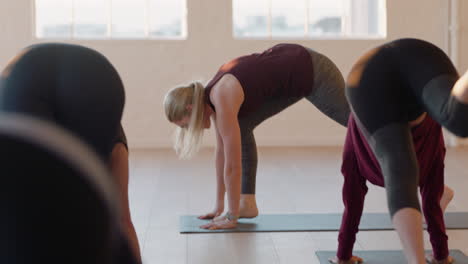 Yoga-Kursleiterin-Unterrichtet-Reife-Frauen,-Die-Bei-Sonnenaufgang-Im-Fitnessstudio-Nach-Unten-Gerichtete-Hundehaltung-üben-Und-Einen-Gesunden-Lebensstil-Genießen