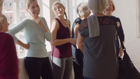yoga-class-of-happy-old-women-chatting-enjoying-healthy-fitness-lifestyle-sharing-conversation-in-wellness-workout-studio