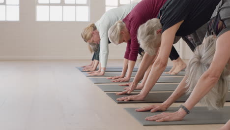 Yoga-Kurs-Mit-Reifen-Frauen,-Die-Gesunde-Meditation-Praktizieren-Und-Die-Pose-Eines-Nach-Unten-Gerichteten-Hundes-üben-Und-Das-Morgendliche-Körperliche-Fitnesstraining-Im-Studio-Genießen