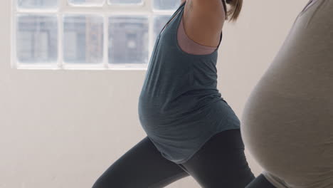 Yoga-Kurs-Für-Junge-Schwangere-Frauen,-Die-Kriegerpose-Praktizieren-Und-Einen-Gesunden-Lebensstil-Genießen.-Gruppenfitnesstraining-Im-Fitnessstudio