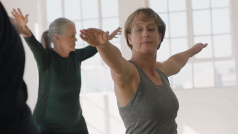 Yoga-Kurs-Schöne-Reife-Frau-Praktiziert-Krieger-Pose-Meditation-Und-Genießt-Das-Körperliche-Fitnesstraining-In-Der-Gruppe-Im-Studio