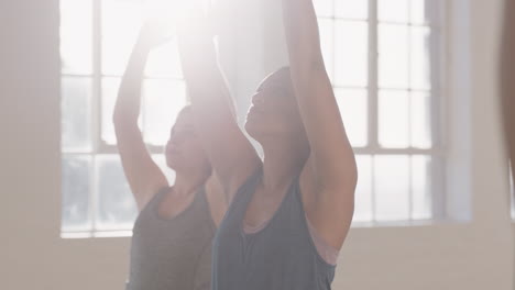 young-pregnant-mixed-race-woman-in-yoga-class-practicing-warrior-pose-enjoying-healthy-lifestyle-group-exercising-in-fitness-studio-at-sunrise