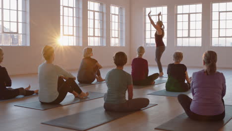 Yoga-Kurslehrer-Unterrichtet-Eine-Gruppe-Reifer-Frauen-In-Meditationsübungen-Und-Zeigt-Posen,-Während-Sie-Das-Morgendliche-Körperliche-Fitnesstraining-Im-Studio-Genießen
