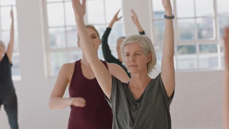 Yoga-Kurs-Für-Gesunde-Reife-Frauen,-Übungsleiterin,-Die-Krieger-Pose-Trainingshaltung-Beibringt-Und-Das-Morgendliche-Körperliche-Fitnesstraining-Im-Studio-Genießt