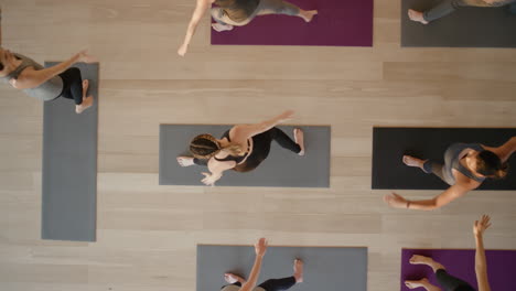 Yoga-Lehrer-Von-Oben-Unterrichtet-Schwangere-Frauen,-Die-Einen-Gesunden-Lebensstil-Ausüben,-Die-Krieger-Pose-üben-Und-Das-Körperliche-Fitness-Workout-In-Der-Gruppe-Im-Studio-Genießen